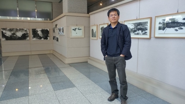 석향 정의주 작가가 자신의 전시회 작품 앞에서 포즈를 취하고 있다. 사진제공= 전북지방경찰청