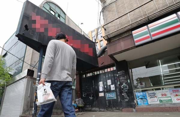 지난 8일 오후 코로나19 확진자가 다녀간 서울 용산구 이태원의 한 클럽 앞으로 시민이 지나가고 있다. 연합뉴스