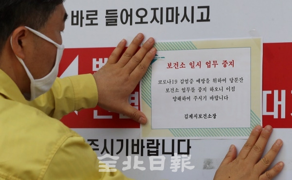 지난 12일 김제시 공중보건의 A씨(33)가 서울 이태원 클럽을 방문한 뒤 코로나19 확진 판정을 받은 가운데 A씨가 근무했던 김제시 보건소에서 관계자가 보건소 일시 업무 중지 안내문을 붙이고 있다. 전북일보 자료사진.
