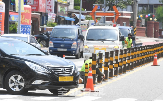 지난 21일 전주에서 민식이법 시행 이후 스쿨존에서 첫 교통사망사고가 발생한 가운데 22일 무단횡단과 불법유턴을 방지하기 위해 중앙선에 교통시설물을 설치하고 있는 도중에도 차량들이 불법유턴을 하고 있다. 전북일보 자료사진