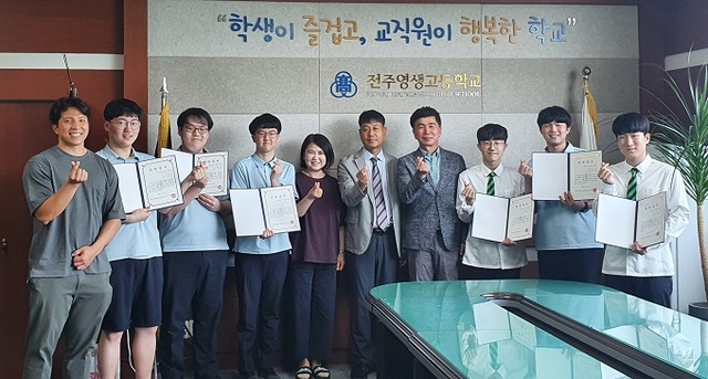 지난 5일  배우 윤균상 씨 아버지와 동생, 교직원 및 장학금을 받은 학생들이 기념촬영을 하고 있다.