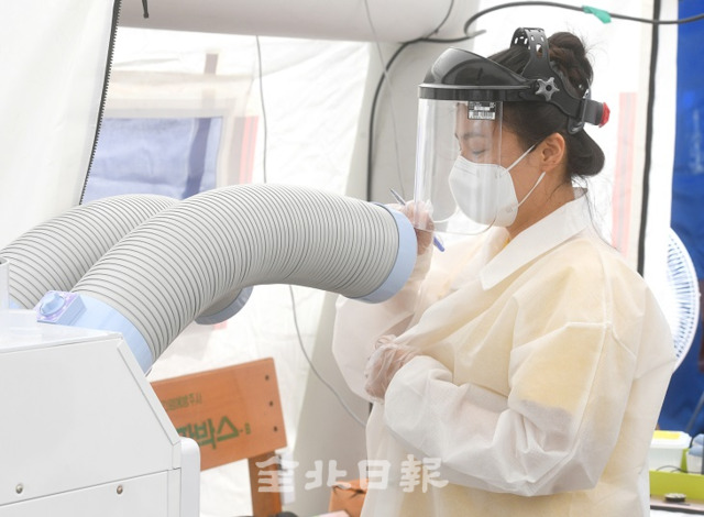 코로나19와 사투중인 의료진들이 통풍이 원할하지 않은 보호복과 보호구 등으로 무더운 날씨 속에 땀으로 온몸이 젖는 이중고에 시달리고 있는 가운데 11일 전주 덕진선별진료소 의료진이 냉풍기 앞에서 잠시나마 더위를 식히고 있다. 오세림 기자