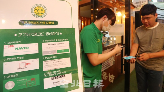 코로나19 확산 방지를 위해 전자출입명부[KI-Pass]가 시행 중인 13일 전주 신시가지의 한 술집을 들어가기 위해 손님들이 발열 확인과 전자출입명부(QR코드)를 찍고 있다. 조현욱 기자