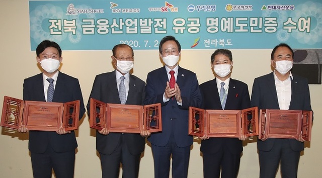 전북 금융산업발전 유공 명예도민증 수여식이 2일 서울 세종대로 달개비 컨퍼런스하우스에서 열린 가운데 송하진도지사가 명예도민증을 수여하고 있다. 왼쪽부터 장부연 현대자산운용 대표이사, 이용만 무궁화신탁 명예회장, 송하진도지사, 오창석 무궁화신탁 회장, 심상형 우리은행 신탁연금단 상무