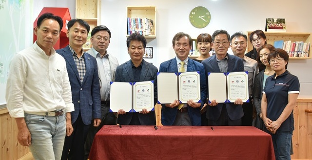 박주진 지사면장, 김판용 지사중교장, 황현중 임실우체국장이 협약서를 들고 참석자들과 기념촬영을 하고 있다.