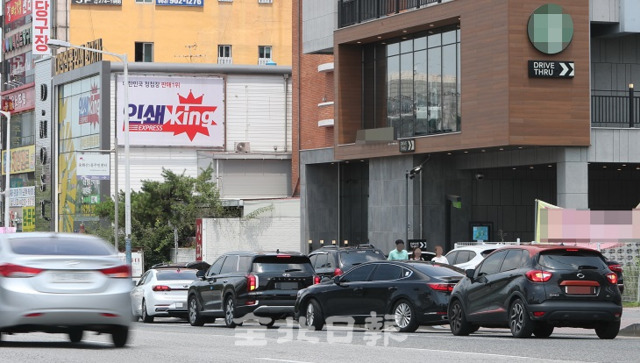 지난 21일 전주시 중화산동의 한 드라이브 스루 매장에 들어가기 위한 차들이 도로에 길게 줄 서 있어 교통체증을 유발하고 있다. 조현욱 기자