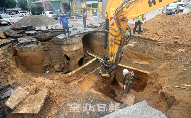 30일 전주시 평화로 일대에 폭우로 인한 큰 싱크홀이 발생해 현장 관계자들이 복구 작업을 벌이고 있다. 조현욱 기자