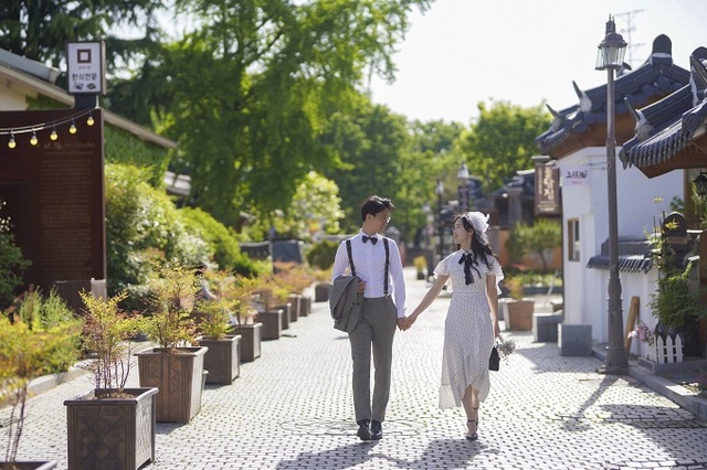 전주 한옥마을에서 한 커플이 골목길을 걷고 있다.