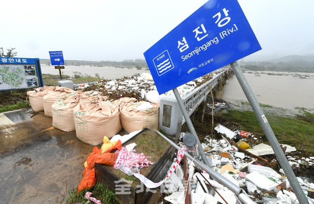 섬진강댐 방류로 섬진강 유역에 홍수피해가 발생한 가운데 10일 귀곡교가 통제된 채 각종 부유물들이 다리를 메우고 있다. 오세림 기자