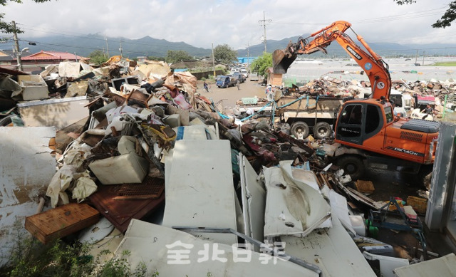 12일 남원시 하도마을 등 폭우 피해지역에서 침수품들이 가득 쌓여 자원봉사자들과 군 장병들, 공무원들이 수해 복구에 힘을 쏟고 있다. 조현욱 기자