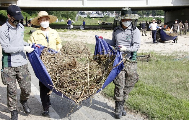 지난 14일 ‘일제 대청소의 날’에 김승수 전주시장이 송천동 신풍교 부근 전주천에서 군 장병들과 함께 하천변 정비 복구에 나서고 있다.