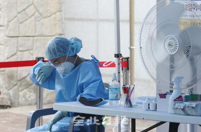 31일 전주시 화산체육관 선별진료소에서 코로나19 장기화와 무더위로 인해 이중고로 사투를 벌이고 있는 한 의료진이 잠시마나 의자에 앉아 땀을 식히며 휴식을 취하고 있다. 조현욱 기자