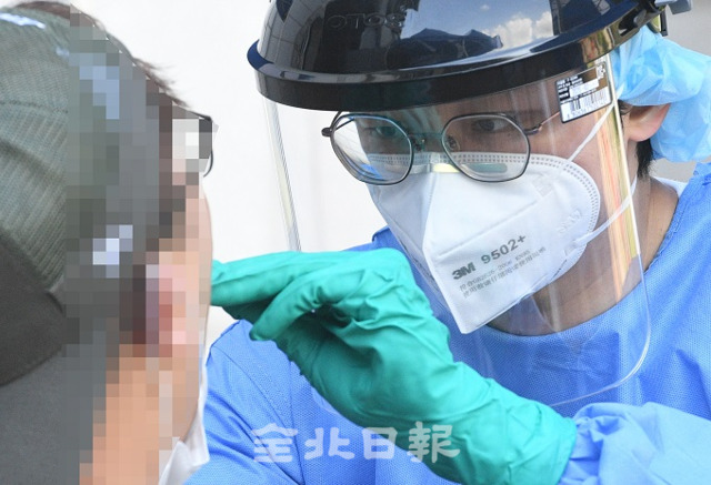 전주 화산체육관 선별진료소에서 코로나19 검사를 위해 시료를 채취하고 있다. 전북일보 자료사진.