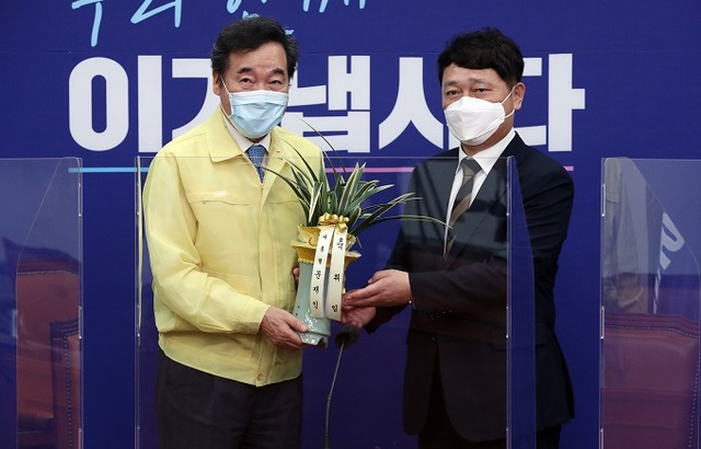 더불어민주당 이낙연 대표가 2일 서울 여의도 국회 더불어민주당 당대표실에서 최재성 청와대 정무수석의 예방을 받고 문재인 대통령의 취임 축하 난을 전달받고 있다. 연합뉴스