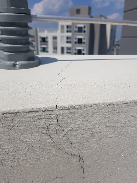 아파트 옥상 벽이 갈라져 있다.