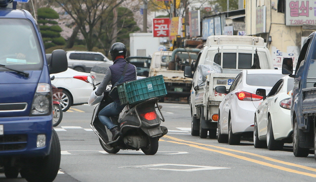 전주 공구거리에서 한 오토바이가 신호대기 중인 차량 옆으로 역주행을 하고 있다. 전북일보 자료사진.