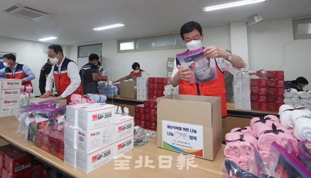 16일 전라북도자원봉사센터에서 열린 '재난지역 주민을 위한 행복 꾸러미 나눔 활동'에서 진영 행정안전부 장관과 김광호 전북 자원봉사센터 이사장, 자원봉사자들이 위생 물품 등이 담긴 박스를 포장하고 있다. 조현욱 기자