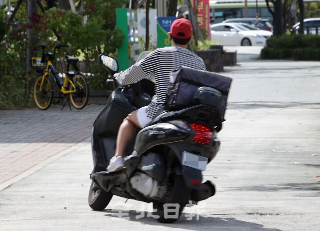 코로나19 여파로 배달 주문이 증가하고 있는 23일 전주시 마전들로에서 한 오토바이 기사가 인도에서 오토바이를 몰고 있어 교통사고가 우려되고 있다. 조현욱 기자