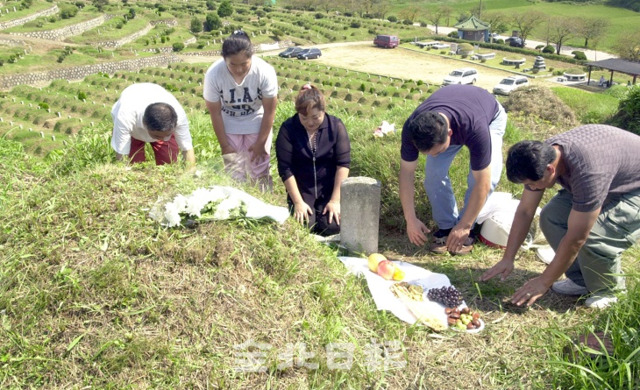 2003년 추석을 나흘 앞둔 9월 7일 한 가족이 전주 화산공원묘지를 찾아 성묘하고 있다.