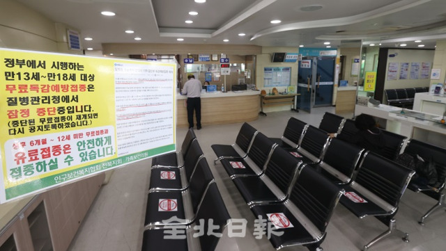 전주시 인구보건협회 전북지회 가족보건의원에서 직원들이 방문객들에게 무료독감 예방접종 잠정 중단을 알리고 있다. 전북일보 자료사진