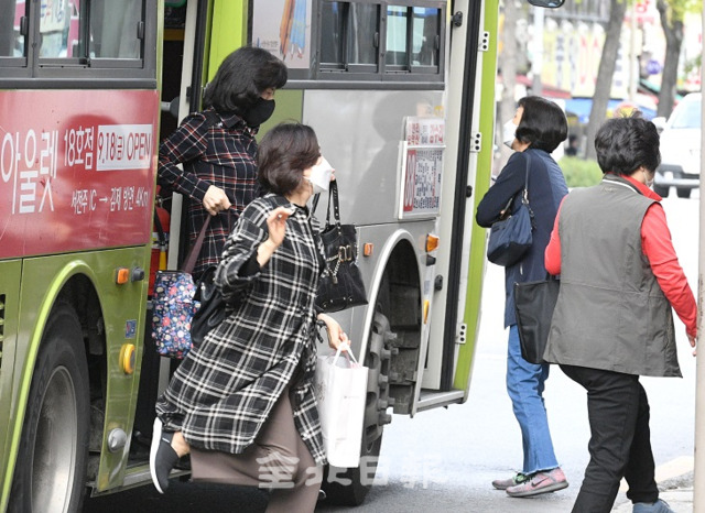 마스크 착용 의무화가 시행된 13일 전주의 한 버스정류장에서 승객들이 마스크를 쓰고 시내버스를 이용하고 있다. 오세림 기자