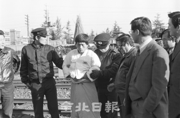 1977년 11월 16일 이리역 폭발사고 범인 신무일 씨가 경찰관과 현장검증을 하기 위해 범행현장으로 가고 있다.