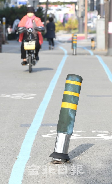 차량의 보도 침입을 방지하기 위해 설치된 볼라드가 자전거도로 한가운데 설치돼 있어 자전거 이용자들의 안전을 위협하면서 4일 한 자전거 이용자가 보도로 운행하고 있다. /오세림 기자