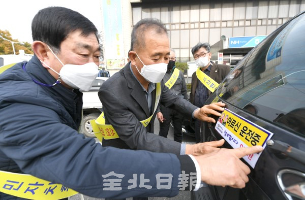 우수 지방자치로 선정된 완주군 고산면 주민자치회 임원들이 차량에 어르신운전중 스티커를 붙이며 봉사활동을 하고 있다. /오세림 기자