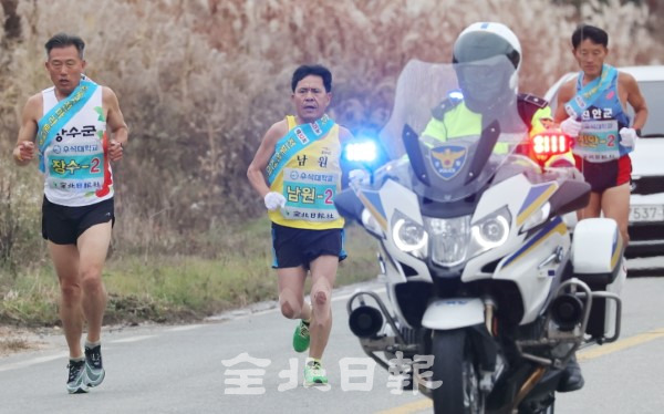 대회 2일 차 참가 선수들이 경찰의 엄호를 받으며 역주하고 있다.