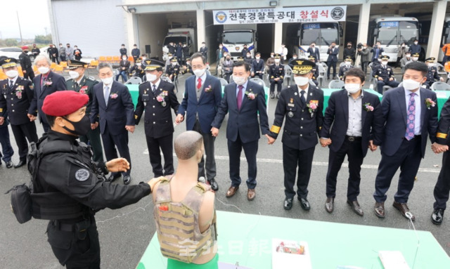 전북경찰특공대 창설식이 18일 완주군 경찰특공대대 운동장에서 열려 송하진 도지사와 진교훈 전북지방경찰청장, 경찰 관계자와 참석 내빈들이 손을 맞잡고 인체의 통전전류를 이용한 폭발물 시연을 하고 있다. /조현욱 기자
