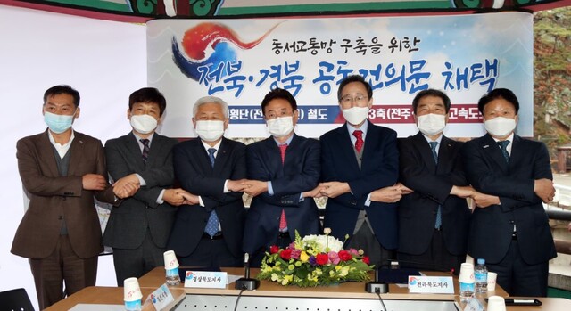 전북-경북 SOC 공동건의문 채택 행사가 19일 무주군 설천면 라제통문 덕유정에서 열려 (좌측부터) 전춘성 진안군수, 최명규 전주부시장, 황인홍 무주군수, 이철우 경북도지사, 송하진 전북도지사,김충섭 김천시장, 이병환 성주군수가 손을 맞잡고 기념촬영을 하고 있다. /사진제공=전북도청