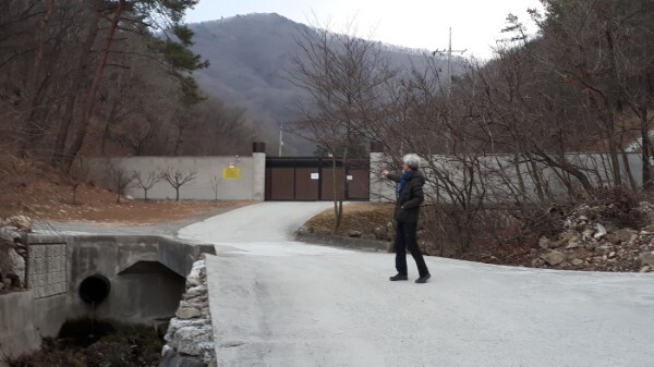 경천면 구재마을 한 주민이 신흥계곡 불법담장과 대문을 가리키고 있다.