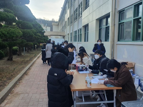 28일 군산의 한 초등학교에서 학생 및 학부모들이 코로나19 선별검사를 받기 위해 긴 줄을 서고 있다.