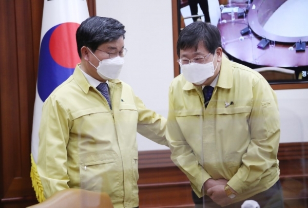 전해철 신임 행정안전부 장관(왼쪽)이 임명된 후 처음으로 24일 오전 정부서울청사에서 열린 신종 코로나바이러스 감염증(코로나19) 대응 중앙재난안전대책본부(중대본) 회의에 참석해 안일환 기재부 2차관과 인사하고 있다. /연합뉴스