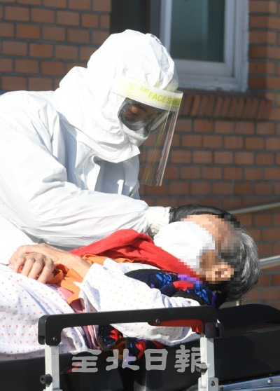 한 의료진이 확진 어르신을 이송하며 정성을 다하고 있다.