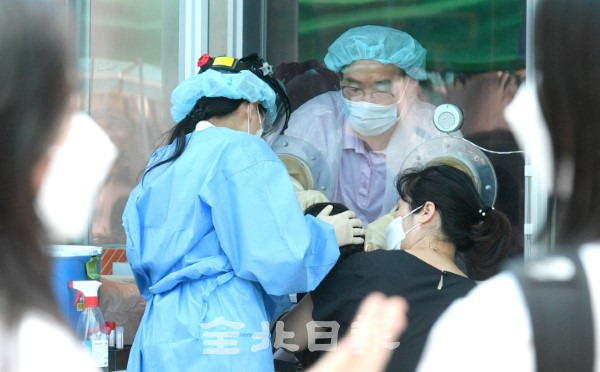 의료진이 방호벽 안에서 선별진료소를 찾은 시민들을 검사하고 있다.