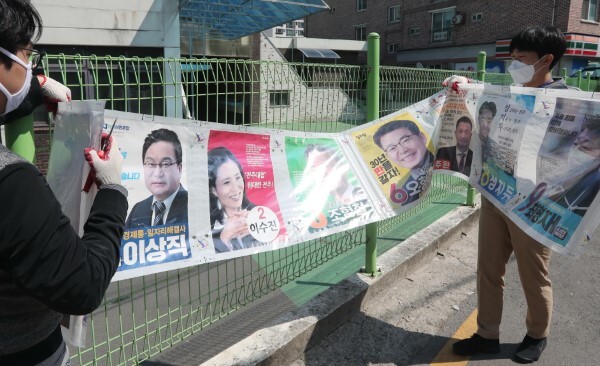 4월 16일 전주시 효자3동 주민센터 관계자들이 담장에 설치된 제21대 국회의원 전주을 선거 벽보 철거작업을 하고 있다