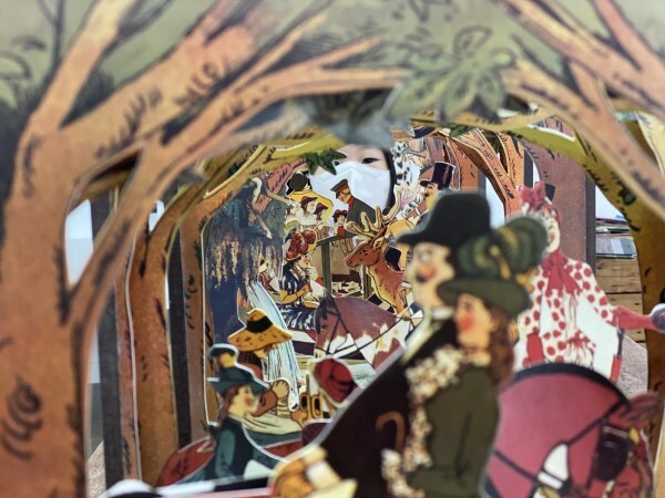 한 아이가 터널북을 신기한듯 보고 있다.