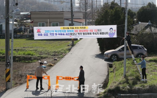 전주시 호성동 한사월마을에서 코로나19 확진자 집단감염이 이어지고 있는 30일 마을 입구에서 관계자들이 이동 제한 조치를 알리는 현수막을 설치하고 출입을 통제하고 있다. /조현욱 기자