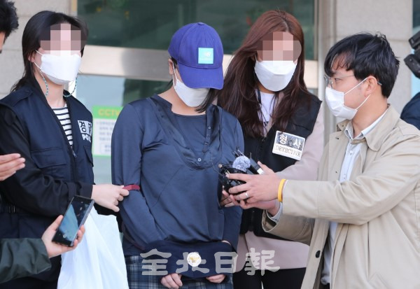 생후 7개월 된 딸을 상습적으로 폭행해 뇌사 상태에 이르게 한 20대 외국인 친모가 30일 덕진경찰서 유치장에서 나와 호송 차량으로 이동하고 있다. /조현욱 기자