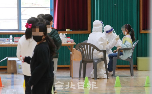 전주 호성동의 한 초등학교에 코로나19 확진자가 발생한 7일 의료진들이 학교 강당에 이동 선별진료소를 설치하고 학생들과 교직원을 대상으로 전수검사를 하고 있다. /조현욱 기자