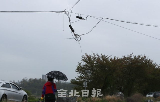 12일 전주시 추천대교 인근 도로에 전선이 끊어질 듯 아슬아슬하게 매달려 있어 위험한 모습을 보이고 있다. /조현욱 기자