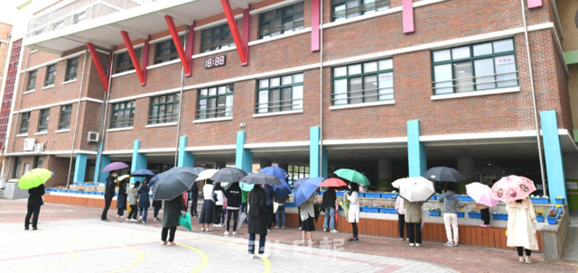 전주의 한 초등학교에서 코로나19 확진자가 발생해 12일 전수검사가 진행돼 불안감에 학교를 찾은 학부형들이 검사를 받고 나오는 아이들을 기다리고 있다. /오세림 기자