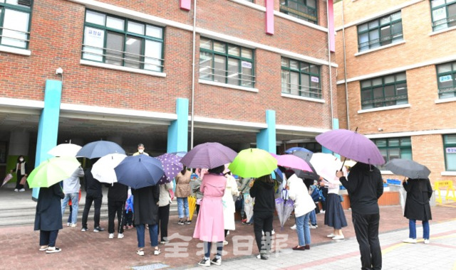 전주의 한 초등학교에서 코로나19 확진자가 발생해 12일 전수검사가 진행돼 불안감에 학교를 찾은 학부형들이 검사를 받고 나오는 아이들을 기다리고 있다. /오세림 기자