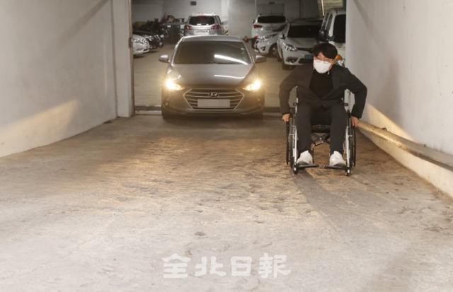 장애인의 날을 하루 앞둔 19일 전주시 평화1동 주민센터 지하주차장에서 본보 안상민 기자가 휠체어를 타고 가파른 차도를 올라가고 있다. /조현욱 기자