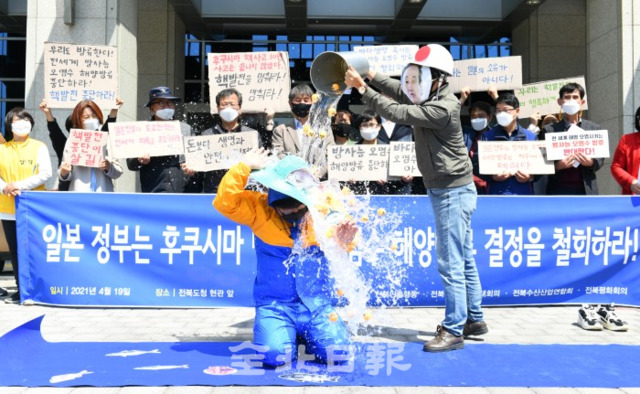 19일 도청 앞에서 도내 시민단체 회원들이 일본 후쿠시아 원전 오염수 해양방류 철회 기자회견을 열고 방사능 오염수를 해양생물에 뿌리는 퍼포먼스를 하고 있다. /오세림 기자