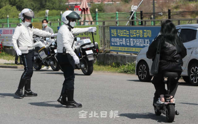 개인형 이동장치(PM)에 대한 안전 규정 강화를 담은 도로교통법 시행 첫 날인 13일 전주 비전대학교에서 앞에서 전북경찰청 교통순찰대가 PM불법행위 단속을 하고 있다. 조현욱 기자