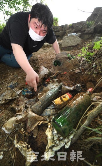 24일 모악산 도립공원 헬기장 등 정상부에 수십년된 각종 생활폐기물이 땅에 묻혀 있다. /오세림 기자