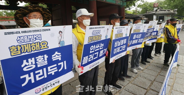 금암노인복지관 어르신들이 10일 전주 한옥마을 일원에서 코로나19 확산방지를 위한 생활 방역 캠페인을 하고 있다. /조현욱 기자