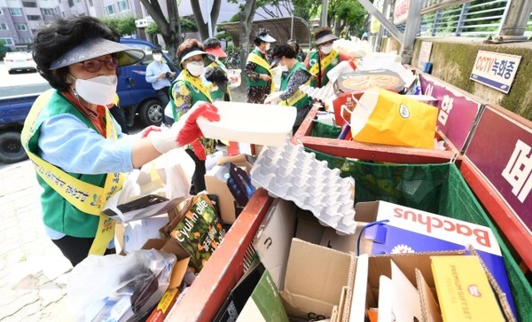 전주시주부환경감시단이 22일 전주의 한 아파트단지에서 제대로 분리되지 않은 재활용 쓰레기를 분리하고 있다. (사진 = 오세림 기자)